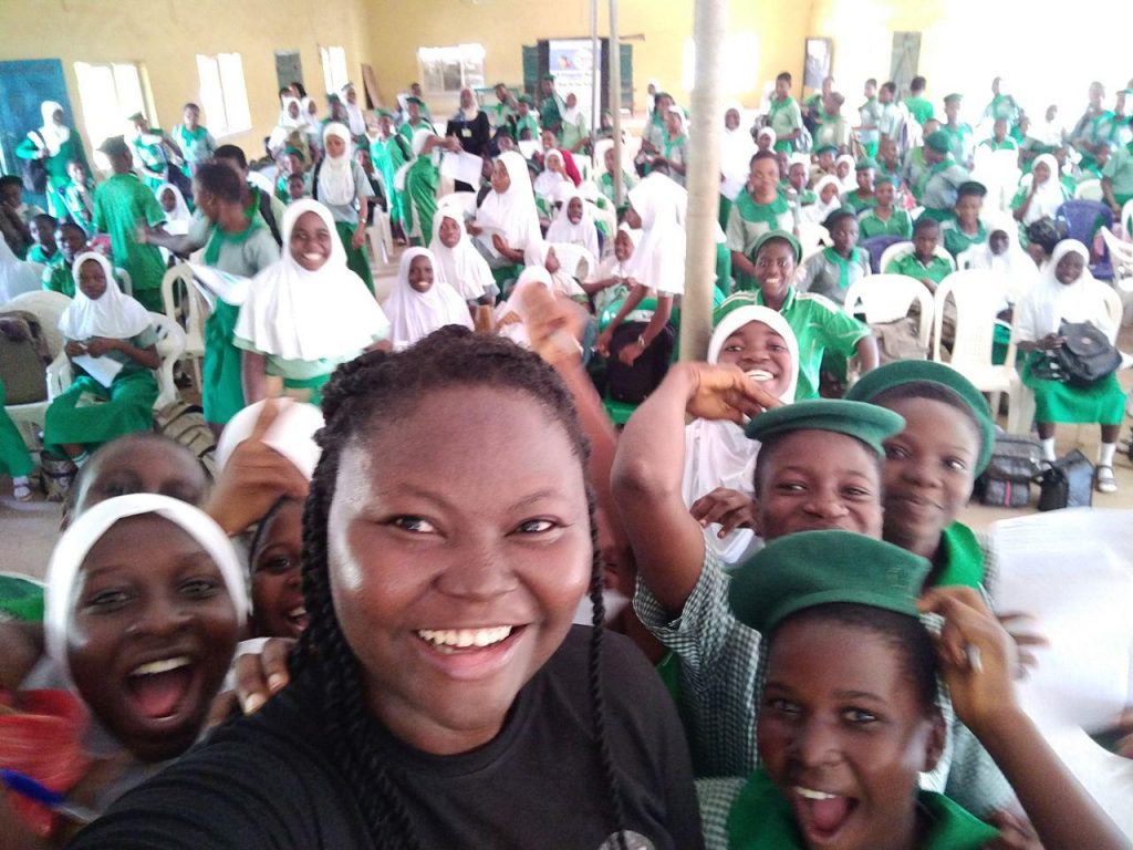 Mary taking a selfie with teens at an Outreach Programme